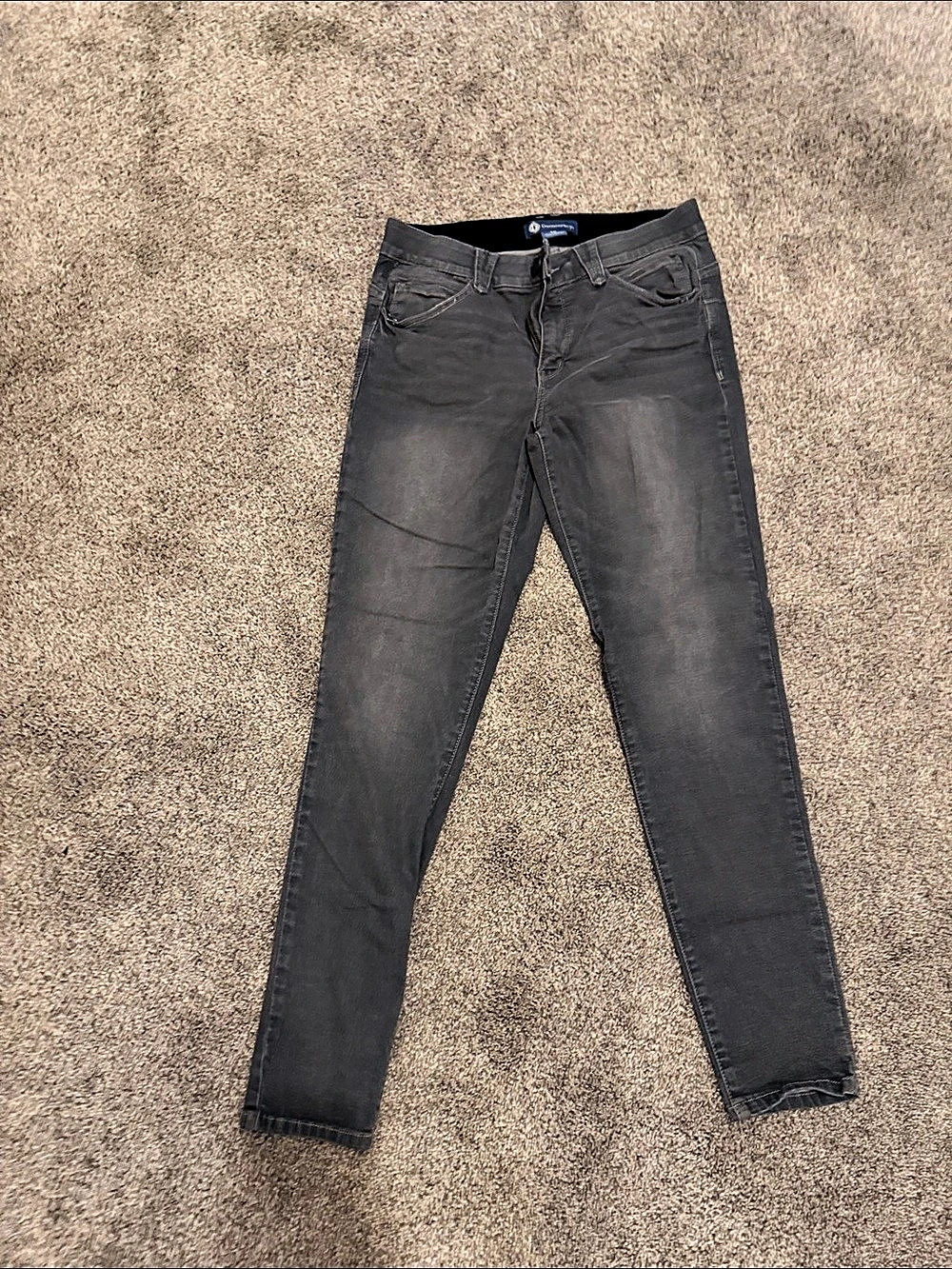 Gray skinny jeans with elastic waist zip fly and button closure